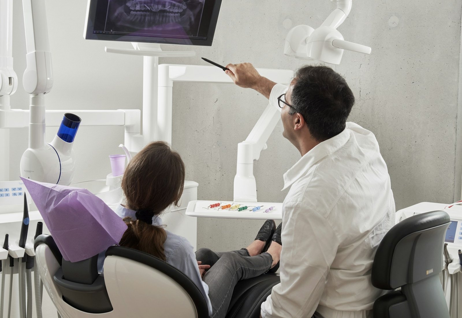 Dentist gently treating a patient in a modern operatory