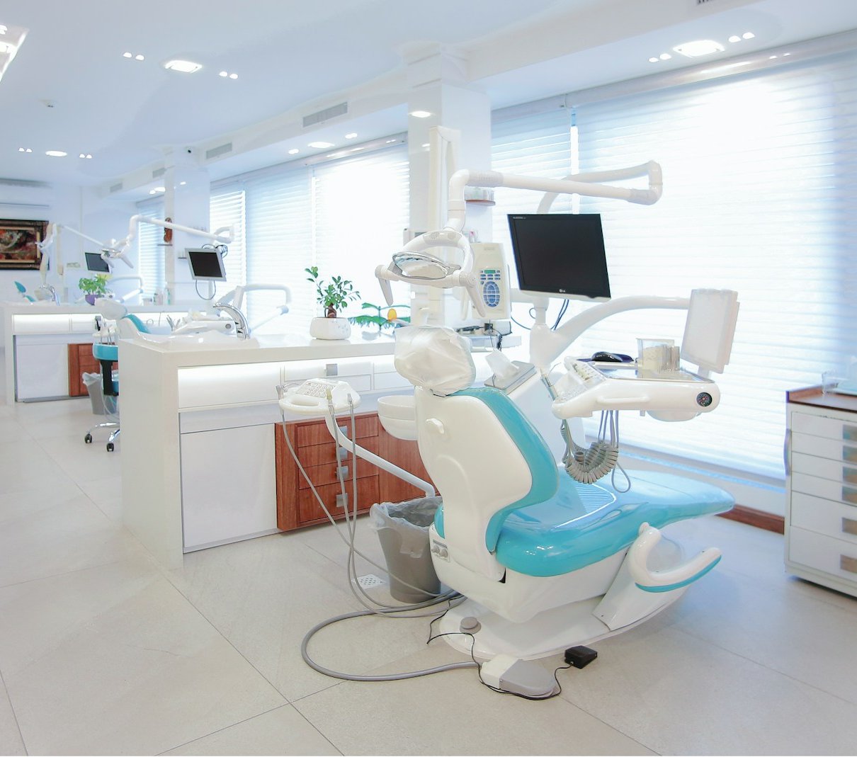 Modern clinic treatment room with a teal dental chair